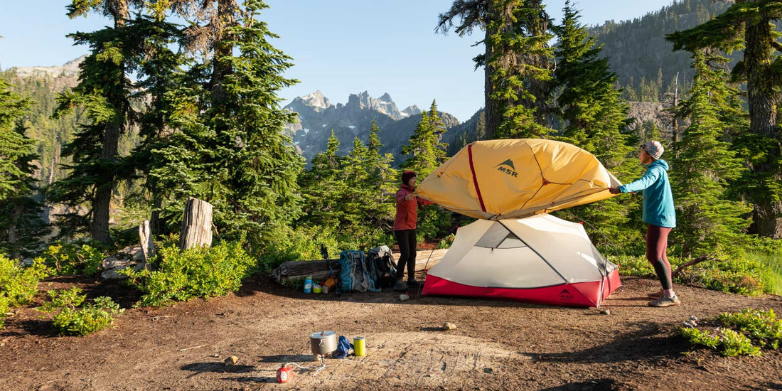 Women backpackers putting rainfly on MSR Hubba Hubba Tent